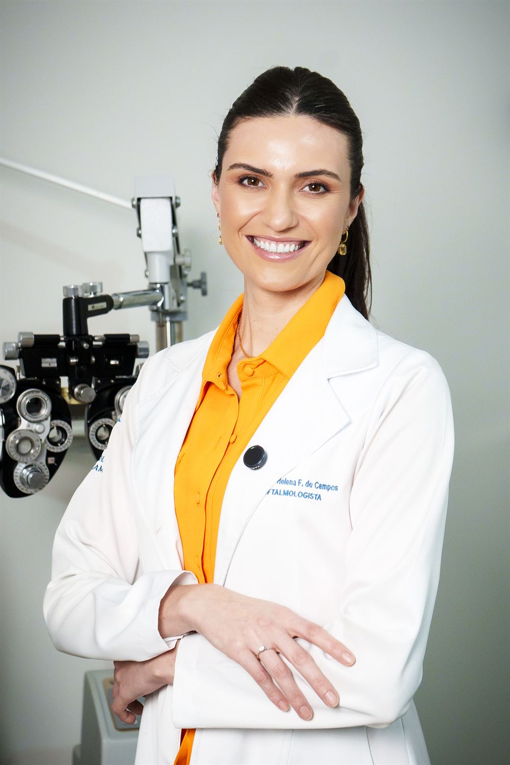 Dra. Ana Helena, médica oftalmologista, de jaleco no consultório